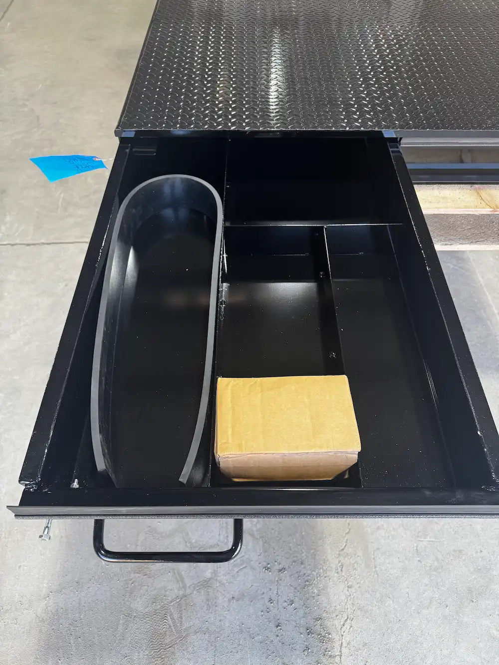 Black truck bed storage box with the left drawer extended.