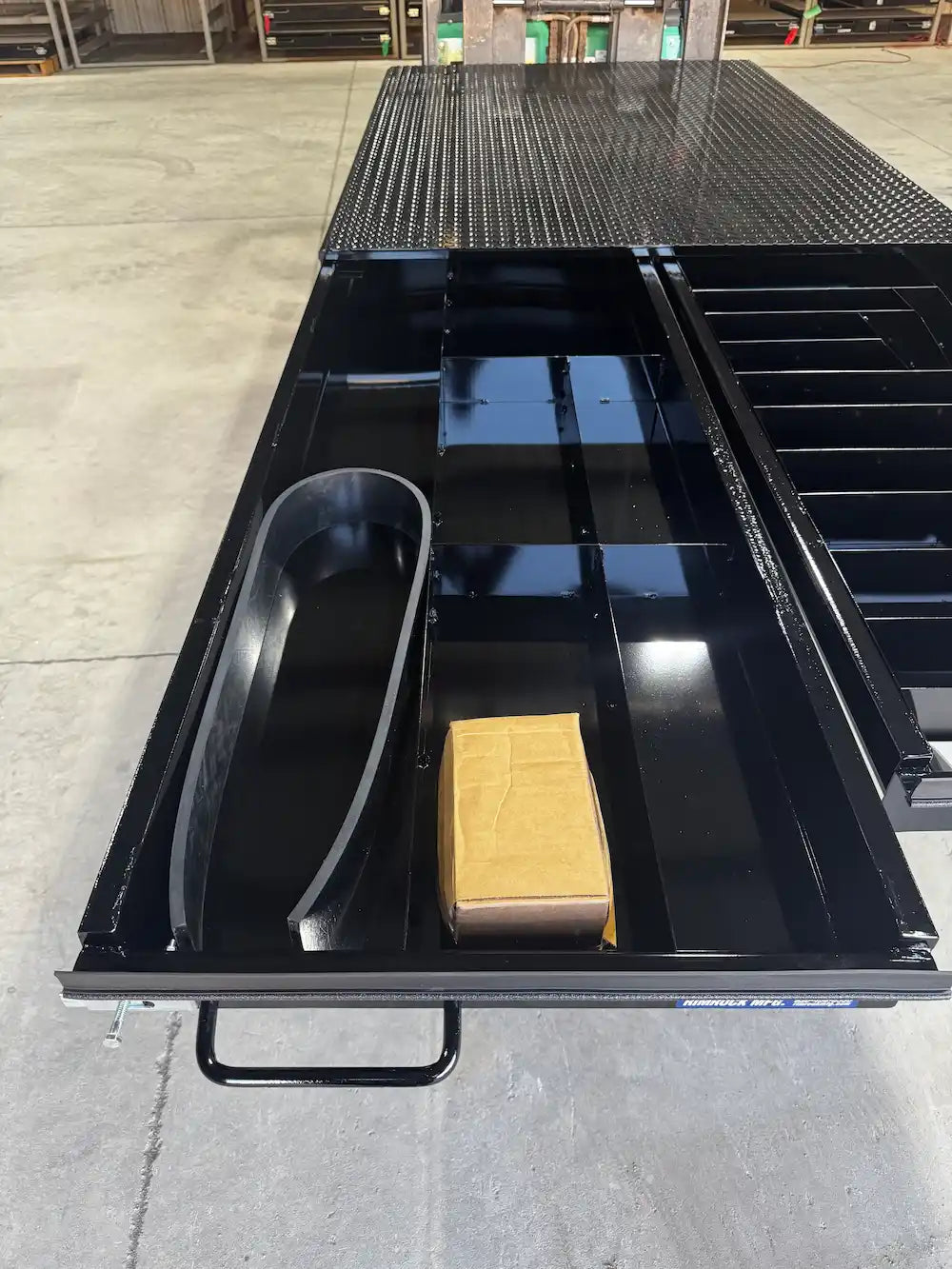 Black truck bed storage system with the left‑hand drawer extended.