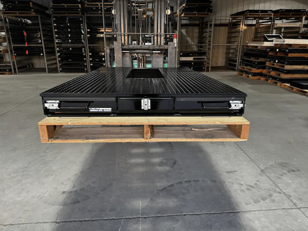 Black truck bed drawer system with open storage compartments.